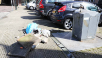 Rommel en tegels naast afvalbak in Havenstraat